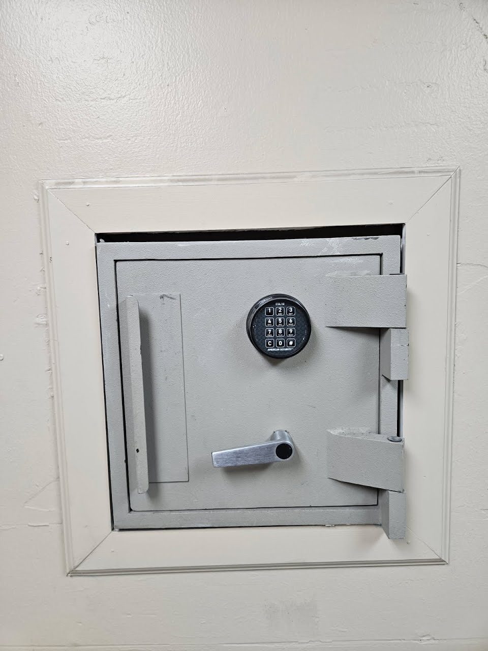Wall-mounted safe with an American Security ESL10 electronic keypad lock and lever handle